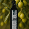 Im Vordergrund ist eine Olivenöl Flasche und im Hintergrund sind Olivenzweige und Oilven zu sehen