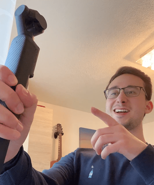 Ein Mann mit einer Kamera in der Hand, der in die Kamera spricht